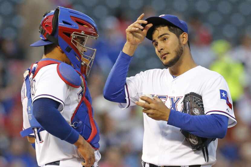Texas starting pitcher Martin Perez visits with catcher Robinson Chirinos during a rough...