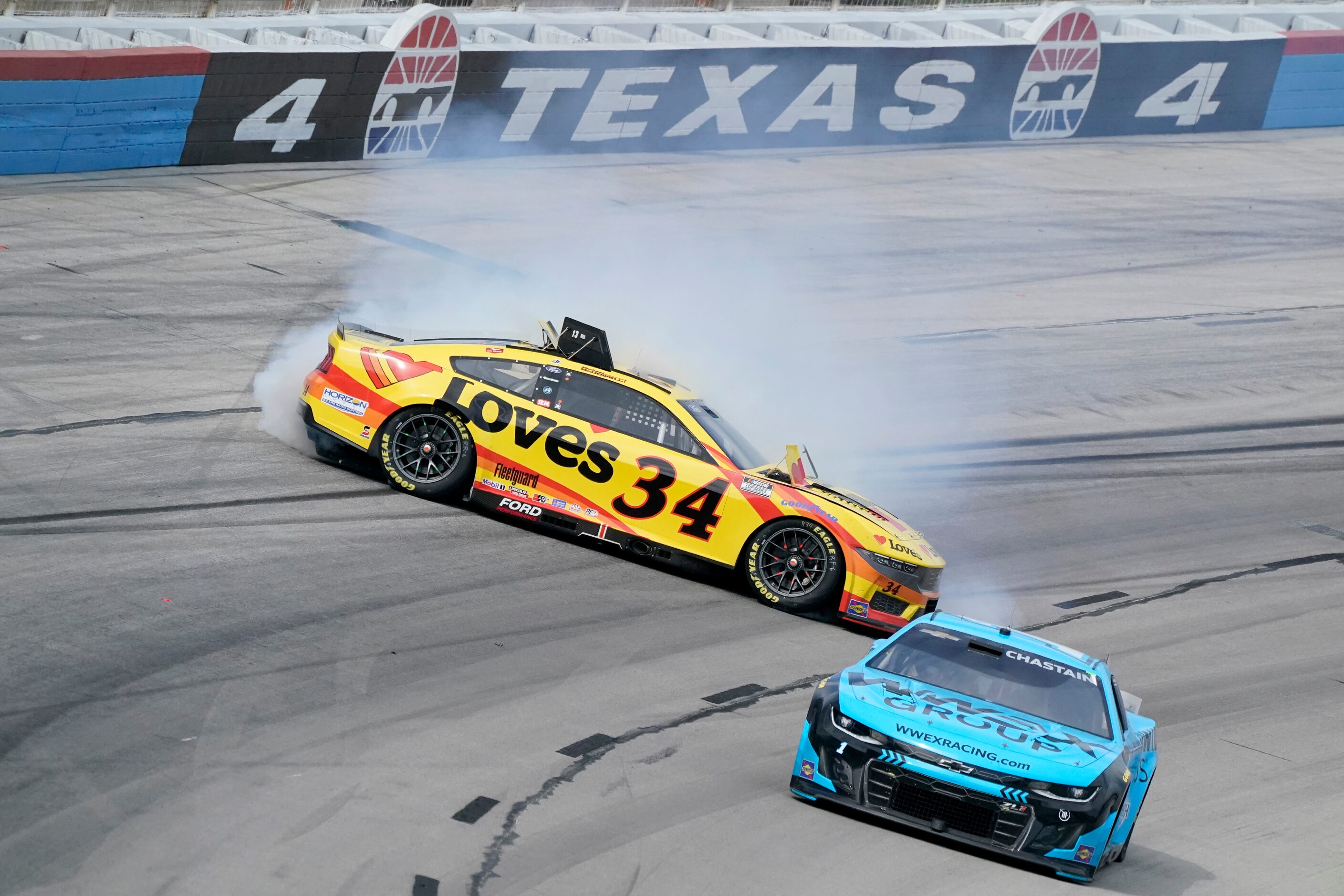 Michael McDowell (34) crashes in Turn 4 as Ross Chastain (1) races past during a NASCAR Cup...