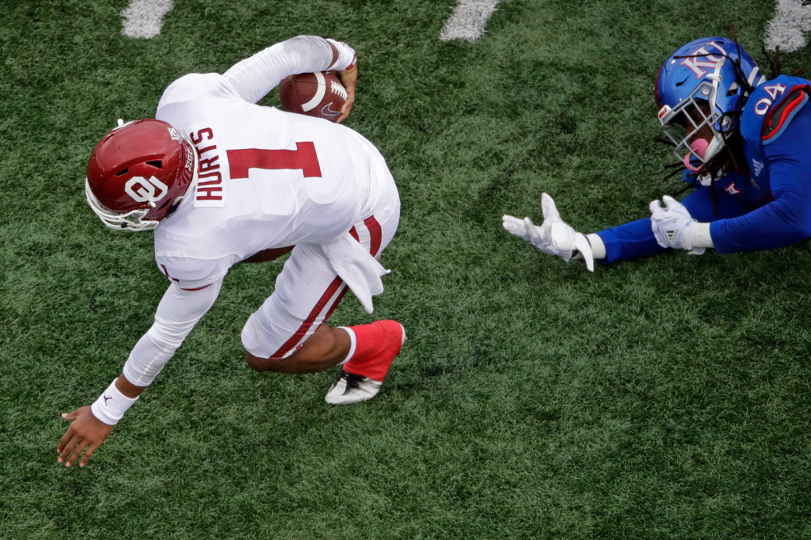 Oklahoma quarterback Jalen Hurts (1) gets past Kansas defensive end Codey Cole III (94) as...