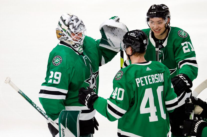 Dallas Stars goaltender Jake Oettinger (29) is congratulated by teammates Jason Robertson...