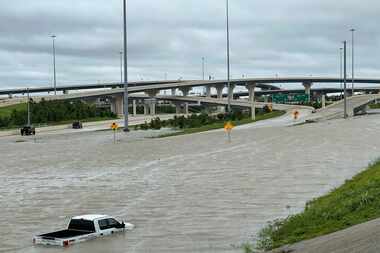 A vehicle is stranded in high waters on a flooded highway in Houston, on Monday, July 8,...