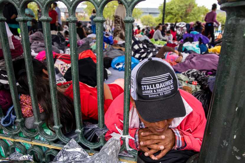 Laureano Sanchez, a migrant from Guatemala, lays among dozens of other expelled migrants...
