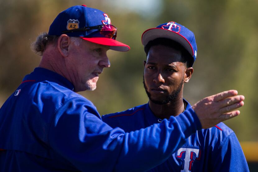 Texas Rangers bench coach Steve Buechele (24) talks to third baseman Jurickson Profar (19)...