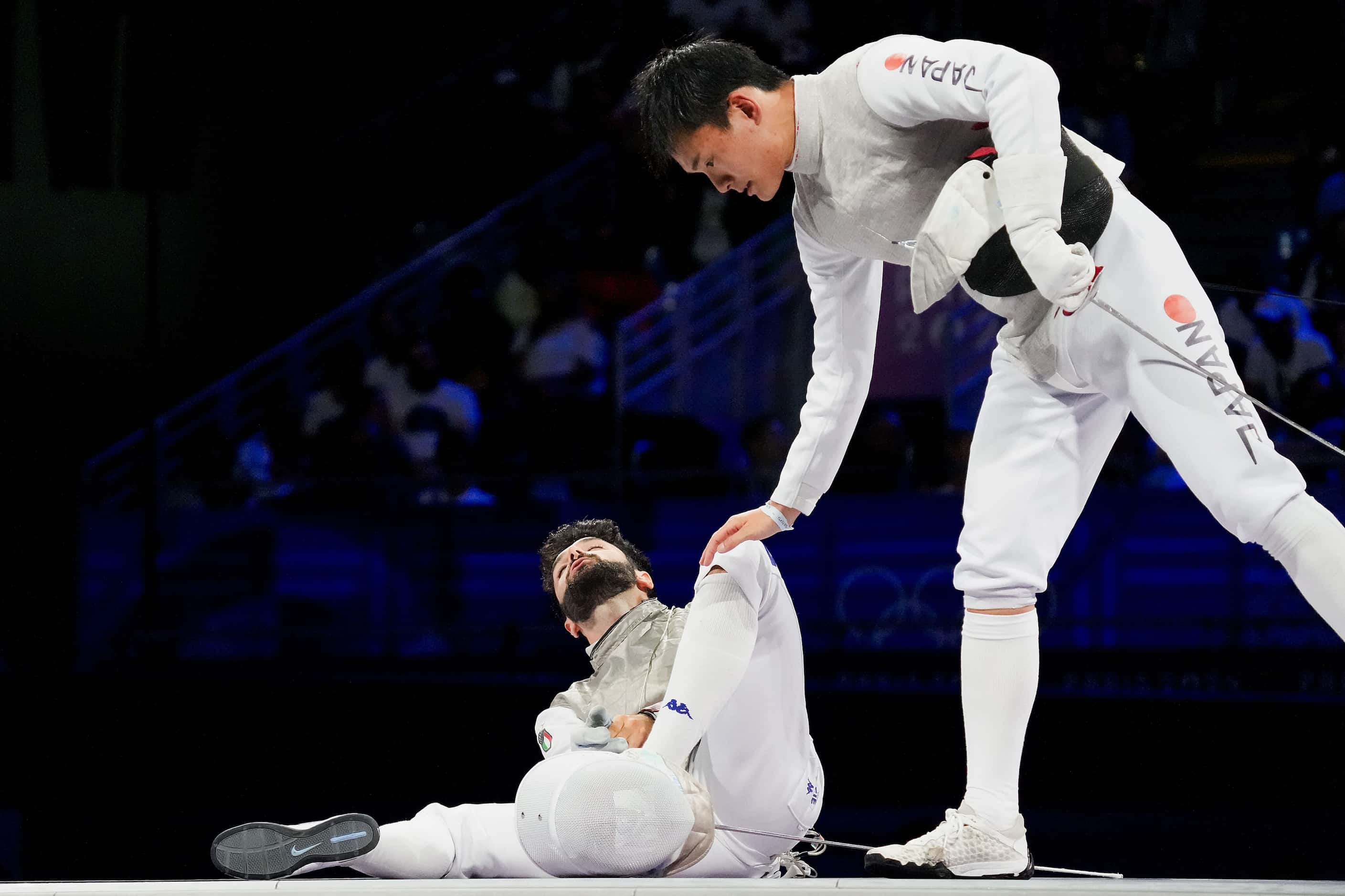Kyosuke Matsuyama of Japan checks on his opponent Guillaume Bianchi of Italy after he was...