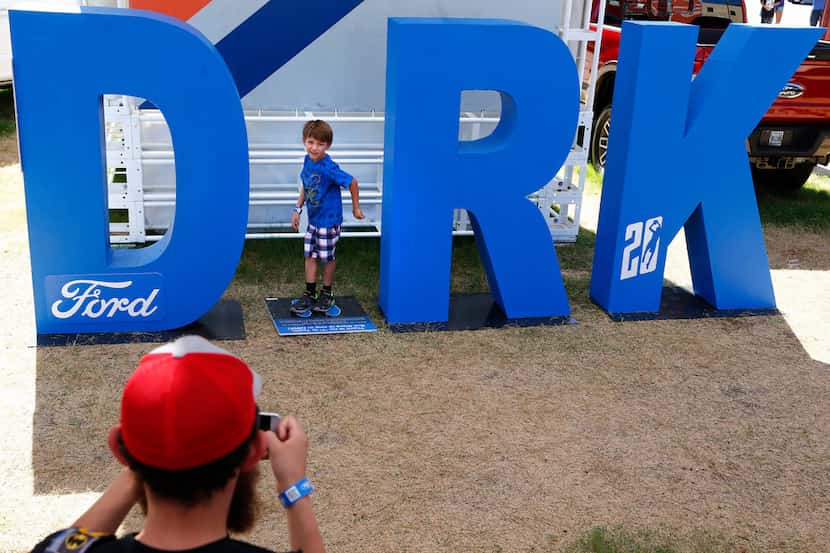 Justin Carvajal takes a photo of his son Loki Carvajal, 5, at the Dirk sign in the Ford...