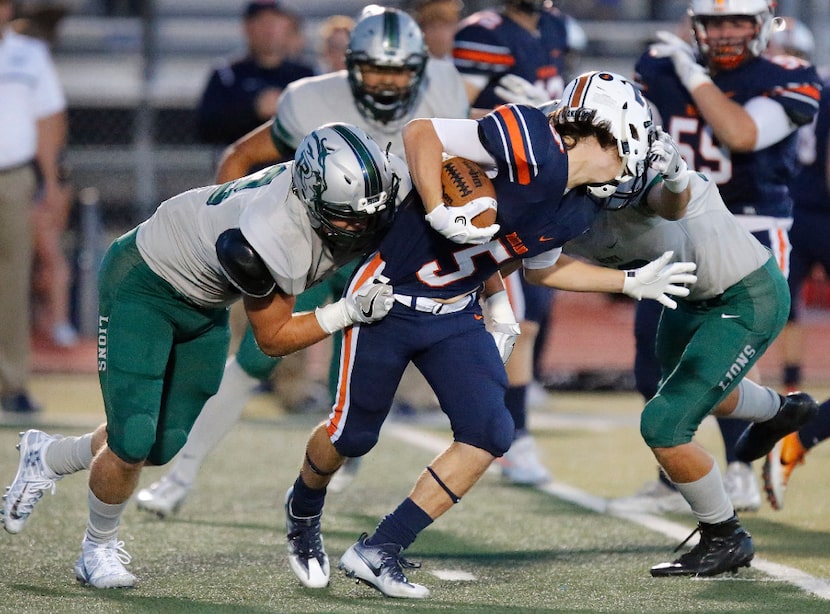 Frisco Reedy High School defensive end Cameron Harris (33) holds Frisco Wakeland High School...