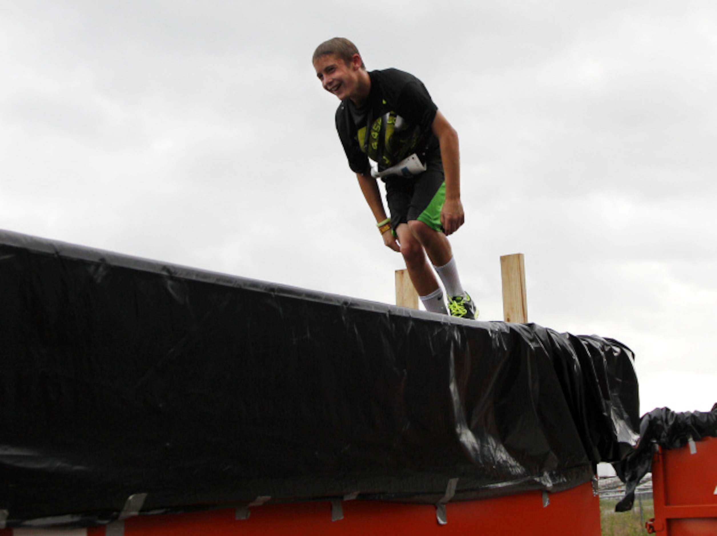 Anderson Perry jumps into a dumpster during the Second Annual Fair Park 5K Urban Dash...