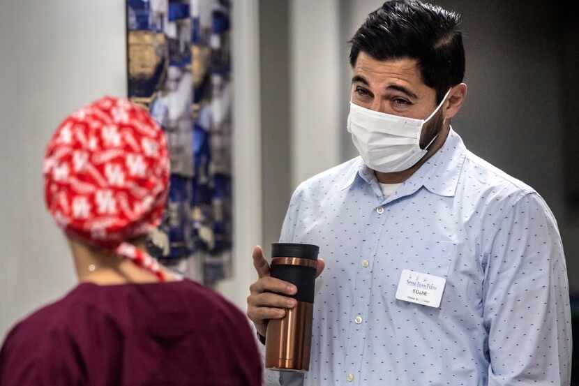 Clinic supervisor Eddie Peña, right, spoke with Dr. Christina Nguyen before she consulted...