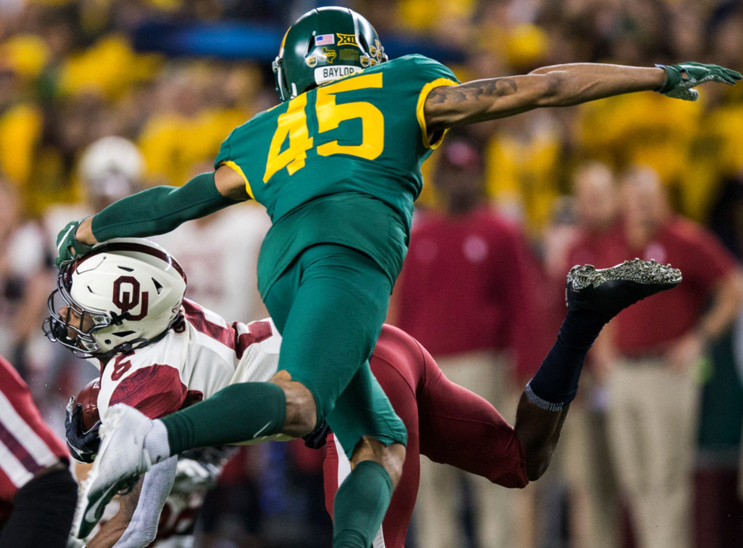 Baylor Bears linebacker Bryson Jackson (45) grabs the facemark of Oklahoma Sooners...