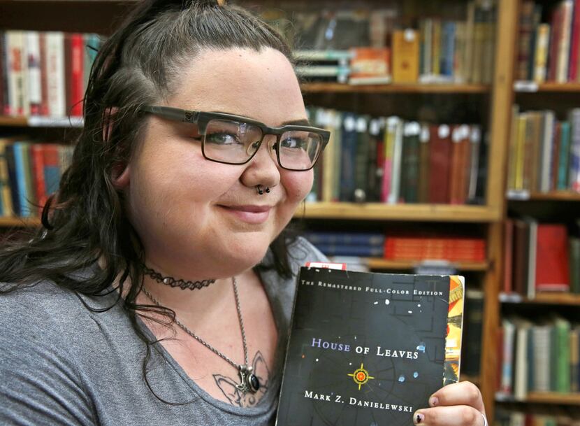 Sarah-Raspberry Farmer of Fort Worth holds a copy of the book House of Leaves, which was...