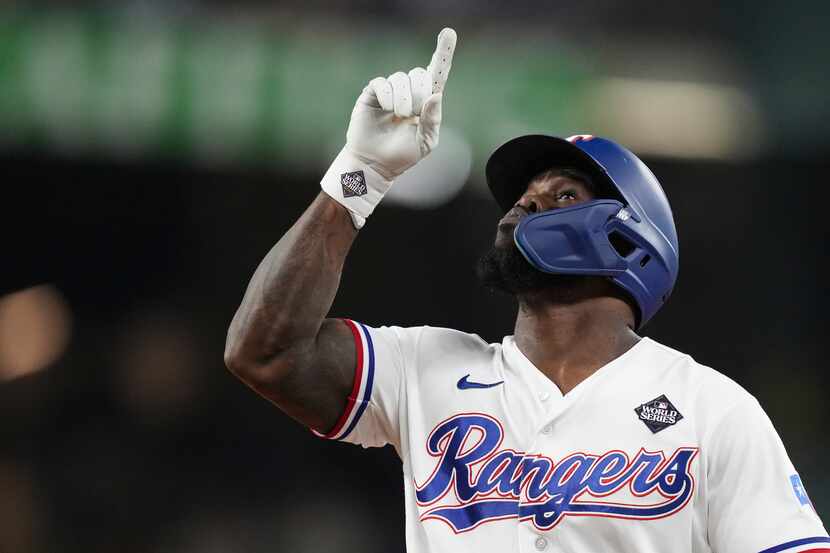 Texas Rangers' Adolis Garcia celebrates after hitting a single during the eighth inning in...