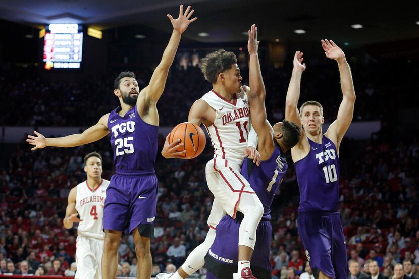 Oklahoma's Trae Young (11) goes up against TCU's Desmond Bane (1), Alex Robinson (25) and...