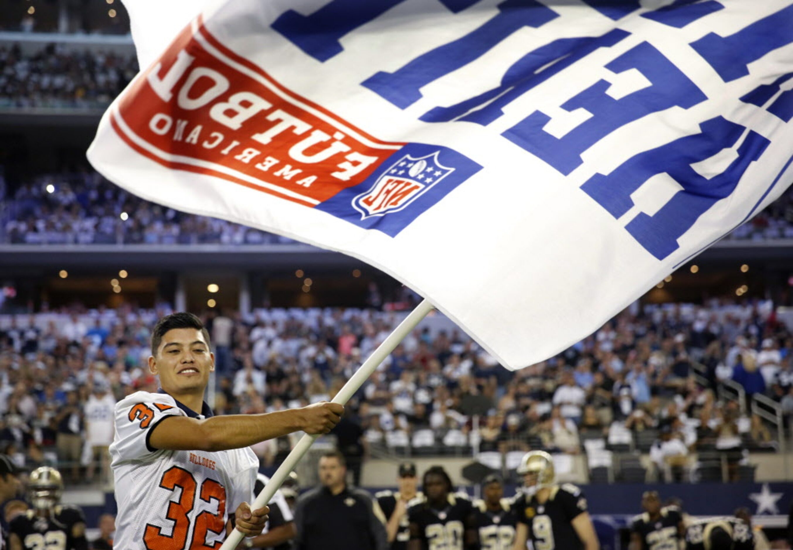 North Dallas High kicker/punter Luis Chaparro proudly waves the NFL Hispanic Heritage flag...