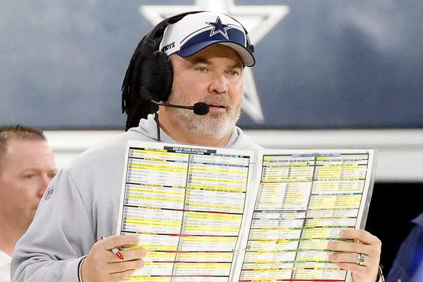 Cowboys coach Mike McCarthy looks over his play sheet during the second half of their home...