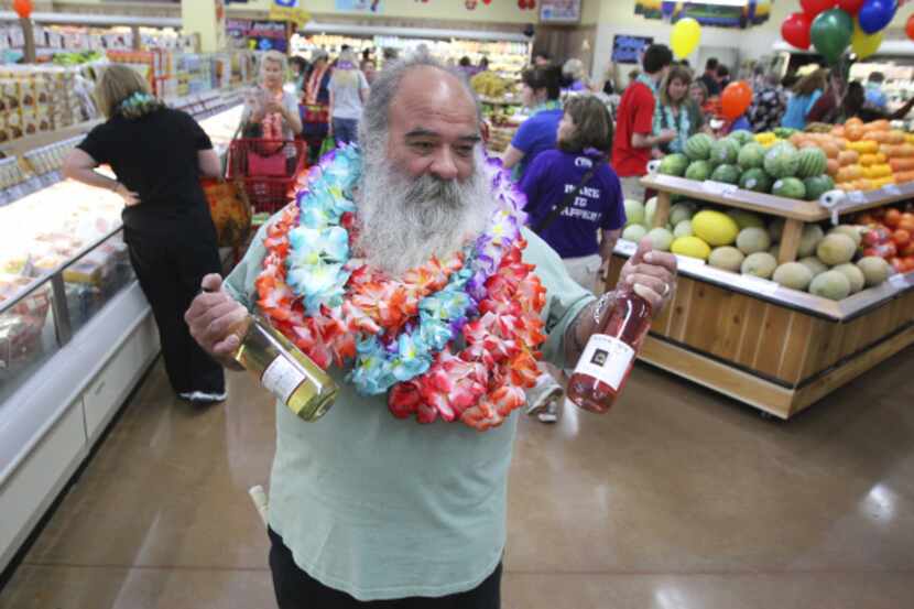 Covered in complimentary leis, Dennis Welch grabbed some wine on his first shopping...