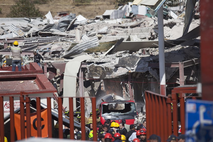 Search and rescue workers inspect the rubble of an explosion at a children's hospital...