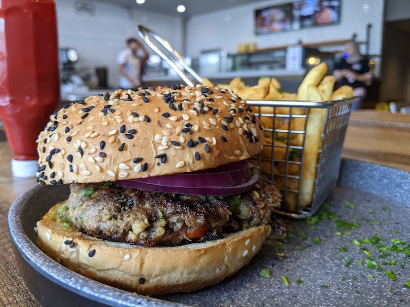 The spicy chapli kebab burger at Adda in Richardson, with ground lamb, seasoning and a slice...