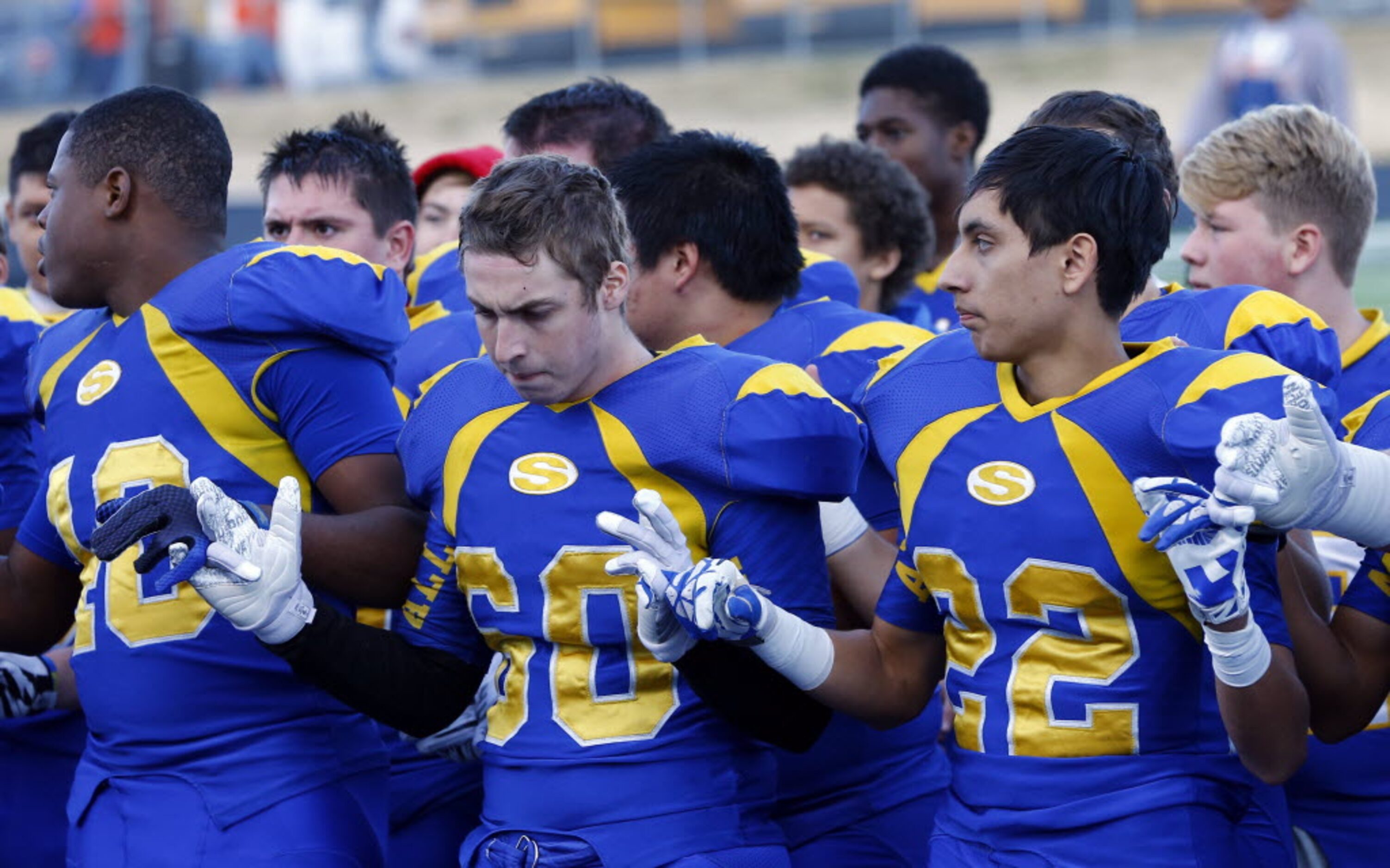 TXHSFB Sunnyvale's Brady Maness (60) and Jaime Suarez (22) looks hands with teammates...