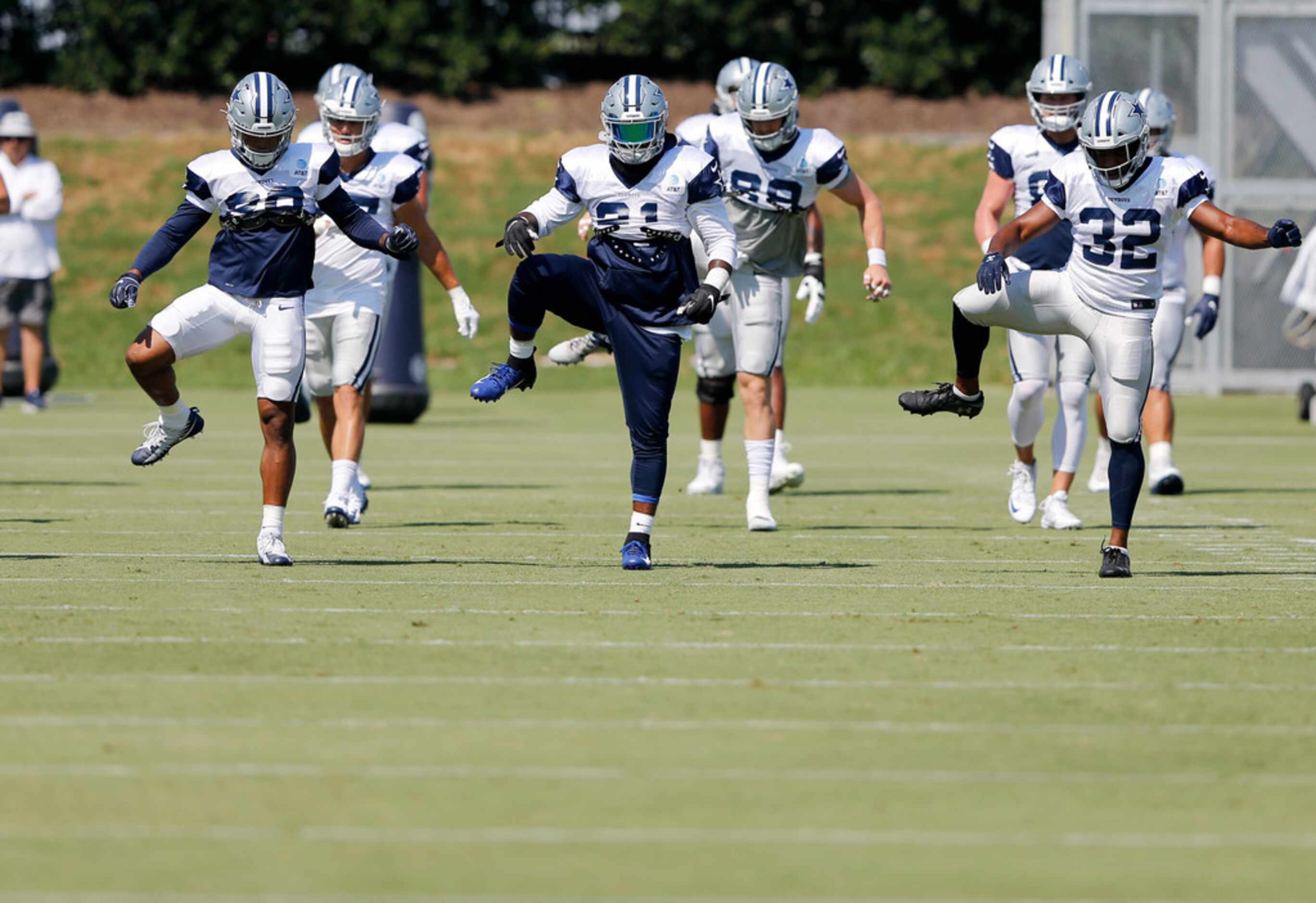 Dallas Cowboys running back Ezekiel Elliott (21) stretches with teammates Dallas Cowboys...