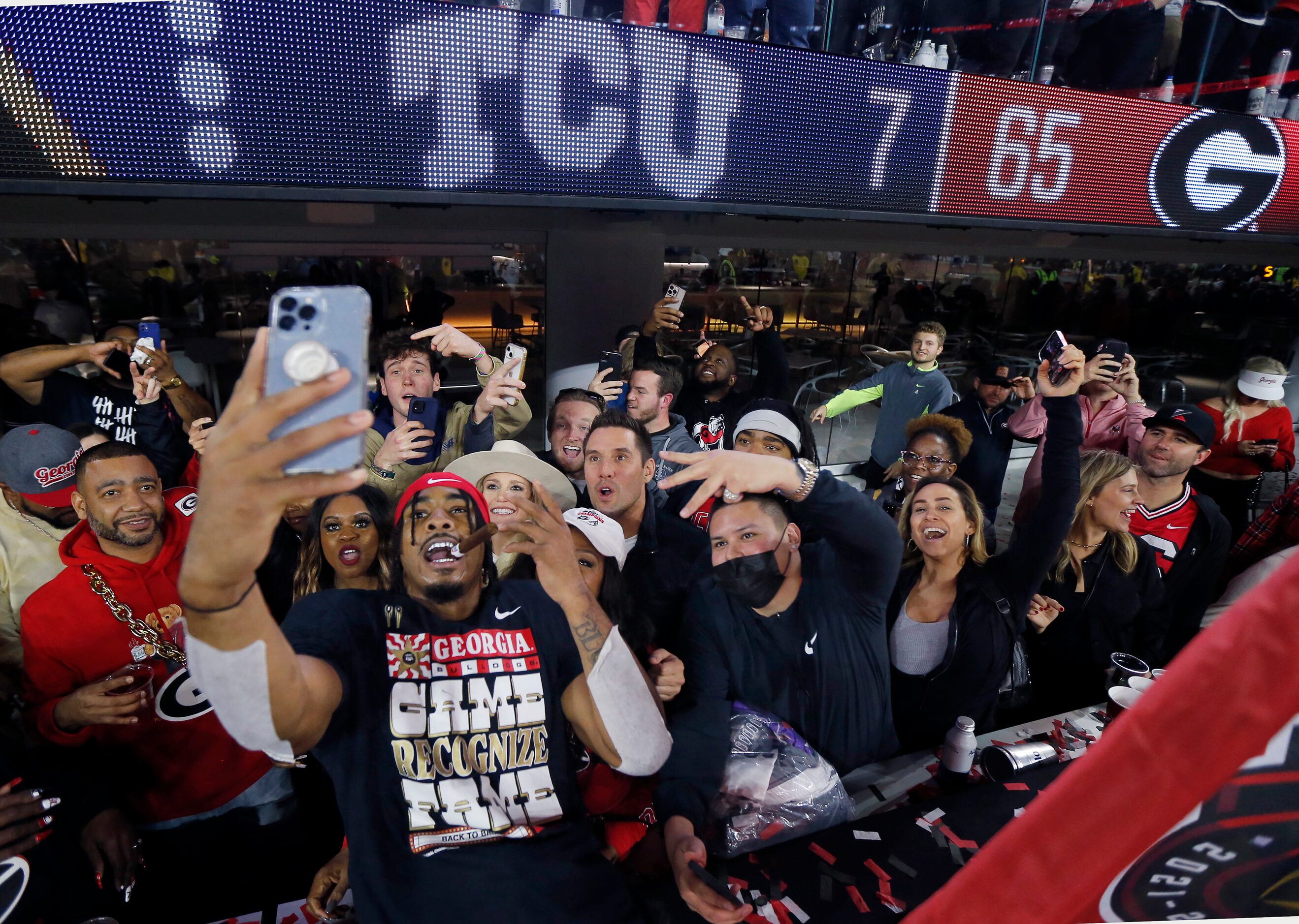 Georgia Bulldogs running back Kenny McIntosh (6) celebrates with a cigar and fans following...