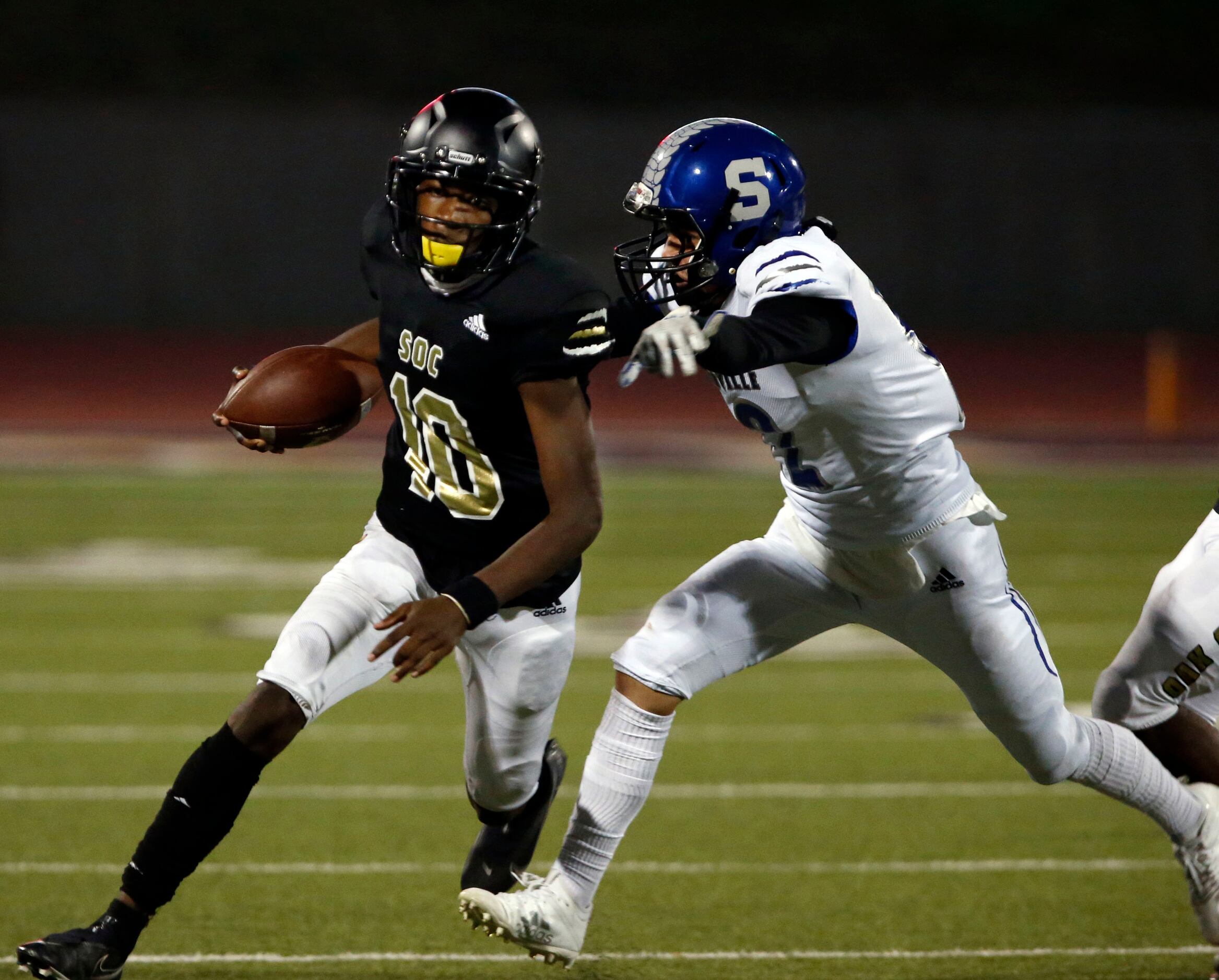 South Oak Cliff QB Kevin Henry-Jennings (10) scrambles away for a Seagoville High defender...