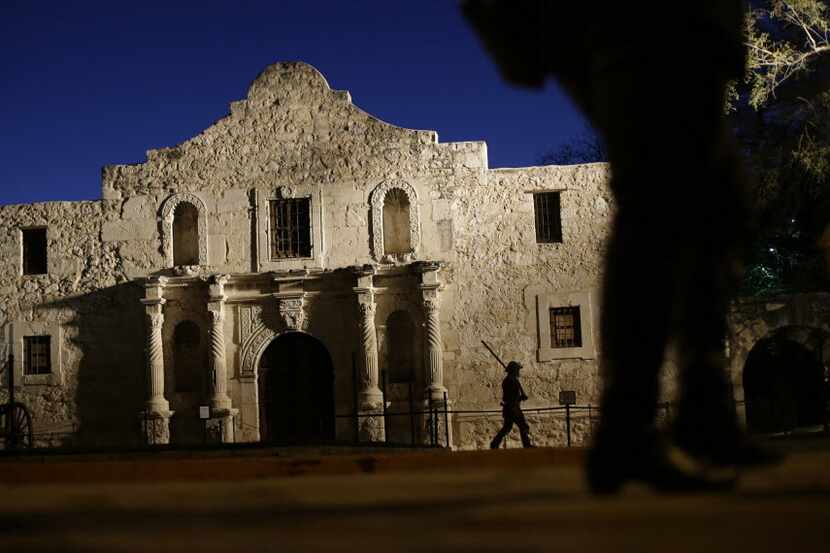  A member of the San Antonio Living History Association patrols the Alamo during a predawn...