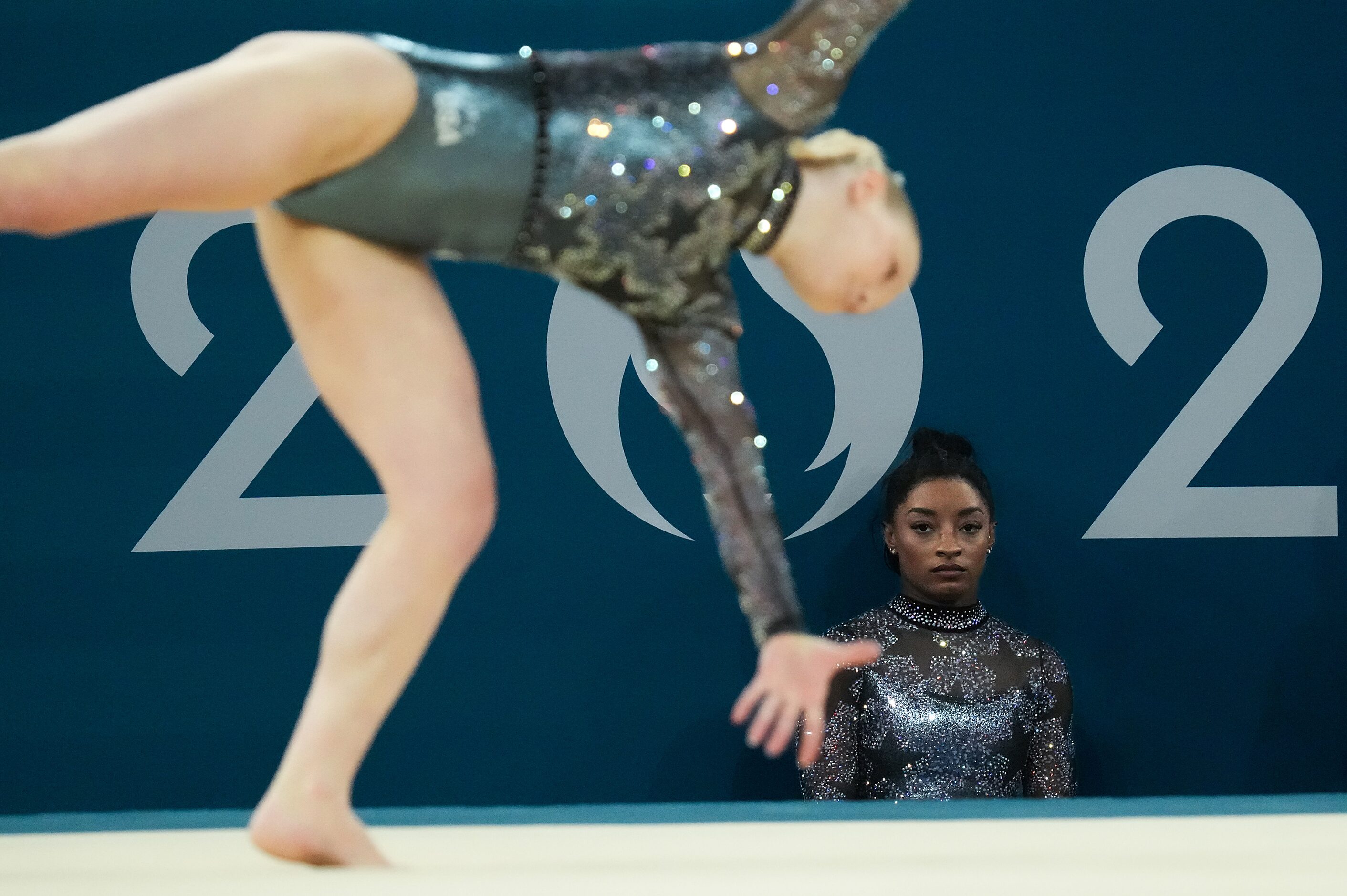 Simone Biles of the United States watches teammate Jade Carey compete on the floor during...