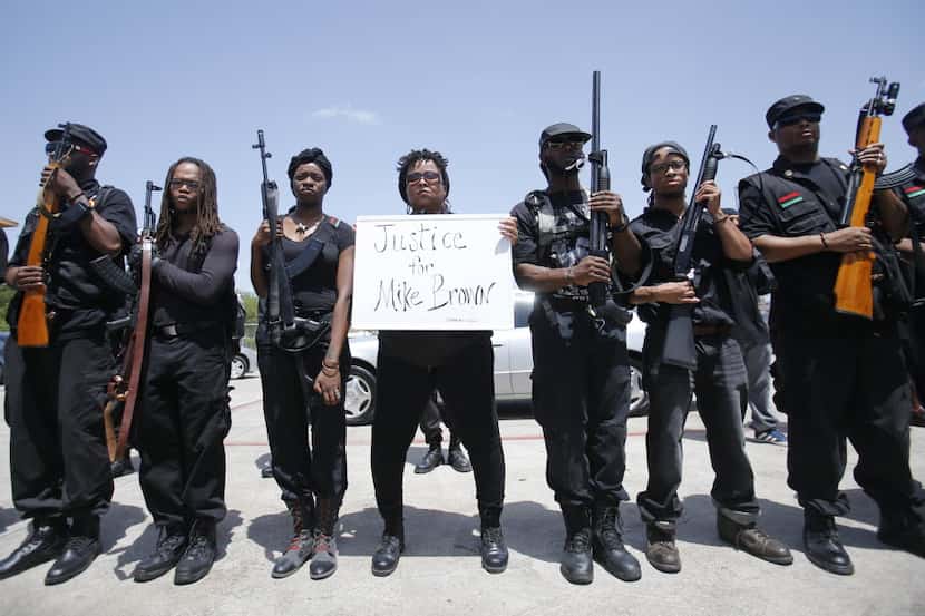 Huey P. Newton Gun Club members and community activists stop for a break in the parking lot...