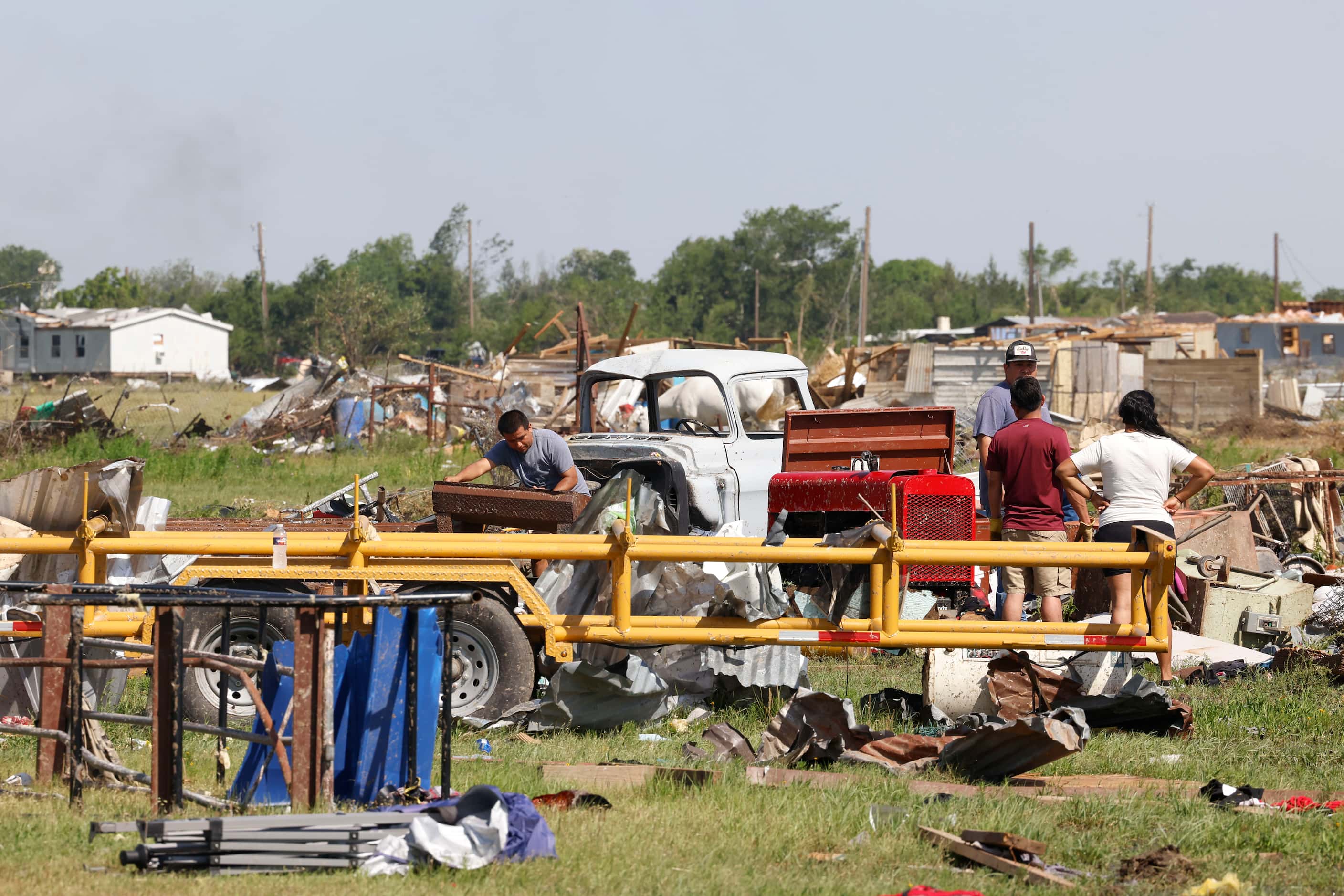 Residents remain by their damaged house, on Sunday, May 26, 2024, along W Lone Oak Rd. in...
