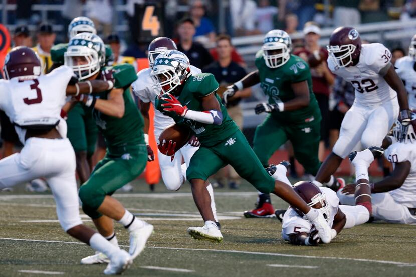 Waxahachie receiver Kenedy Snell (2) finds a hole past the Ennis defense in the first...