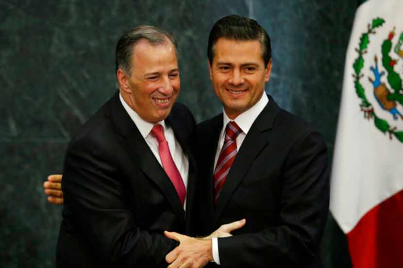 El presidente mexicano Enrique Peña Nieto (derecha) abraza al saliente secretario de...