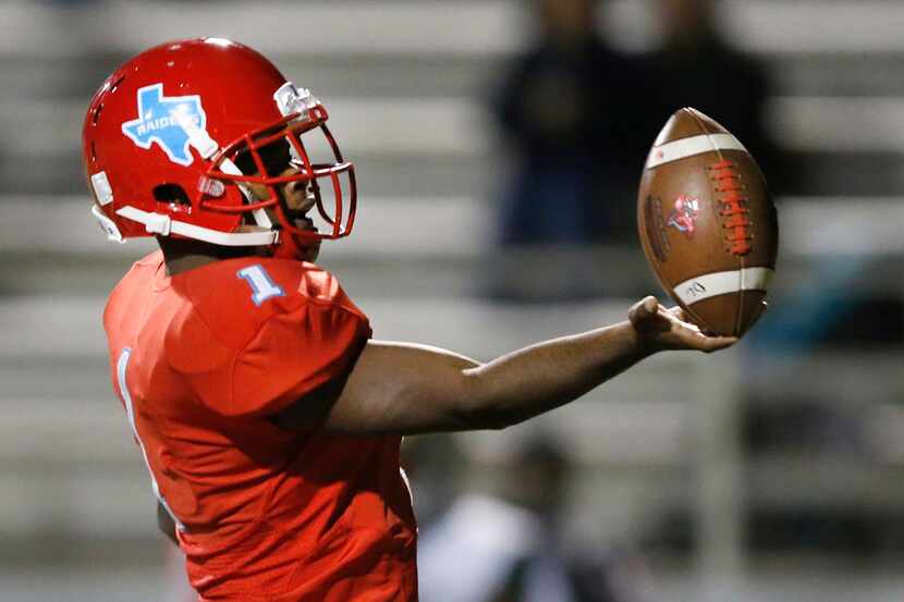 Skyline quarterback Velton Gardner (1) flips the ball to to an official after scoring a...