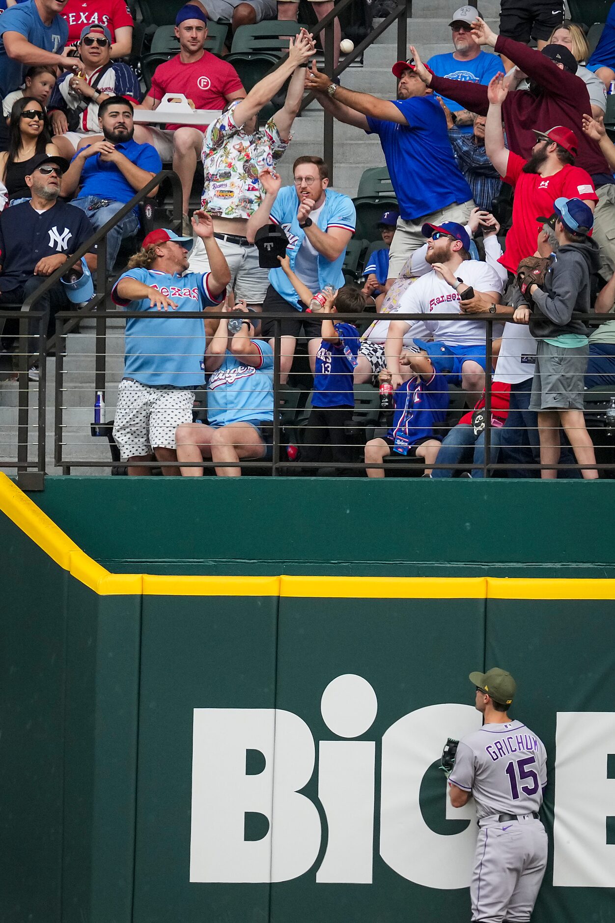 Fans reach for the ball on a two-run home run by Texas Rangers designated hitter Corey...