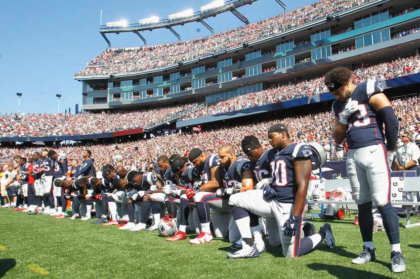 FOXBORO, MA - SEPTEMBER 24:  Members of the New England Patriots kneel during the National...