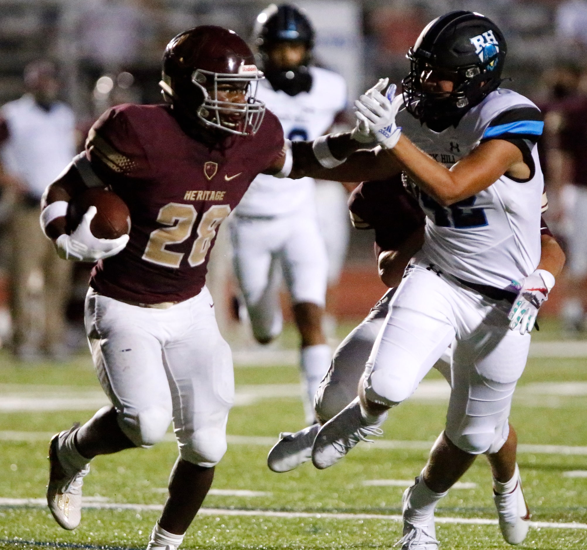 Heritage High School running back Shawn Wara (28) stiff arms Rock Hill High School...