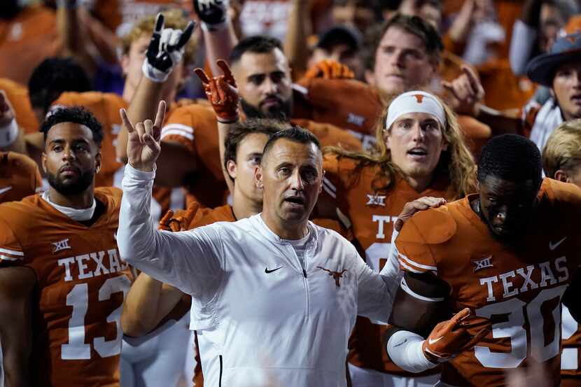 Texas head coach Steve Sarkisian, center, stands with players for the school song following...