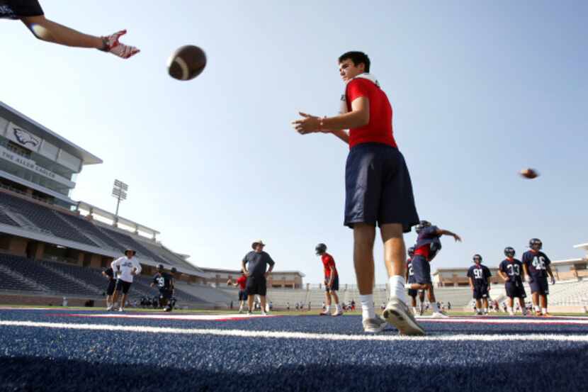 Quarterback Conner Greenberg catches a toss during Allen Eagles first football practice in...