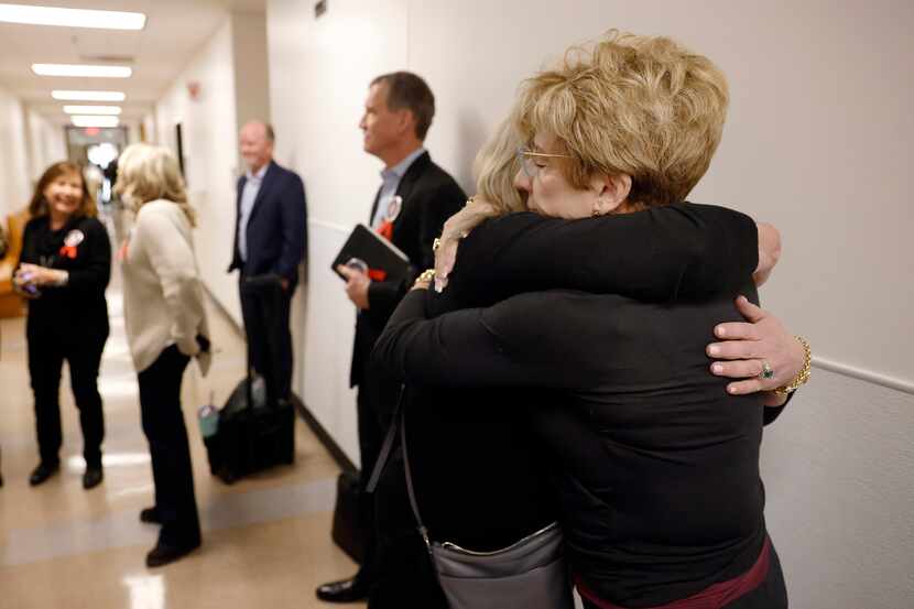 Shannon Dion (right), daughter of Doris Gleason, receives a hug as victims families gathered...