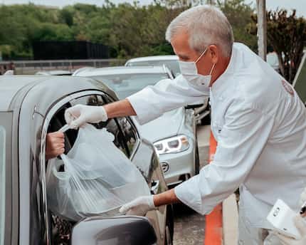 Executive chef and Fort Worth restaurant owner Jon Bonnell hands food to a driver during the...