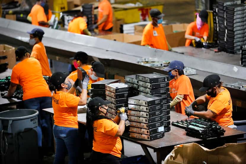 Employees disassemble stacks of cable boxes at Echo Environmental, an electronic recycling...