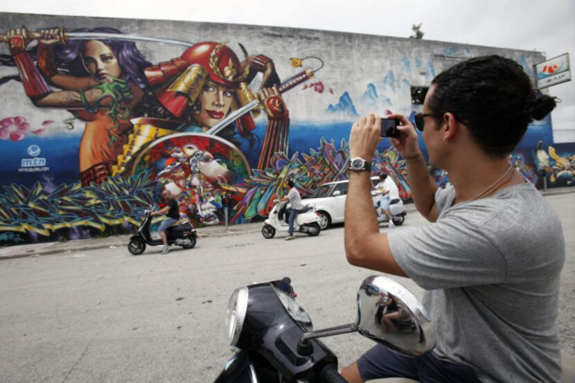 Philipe Almeida takes a picture of a graffiti covered wall during a two-hour graffiti tour...