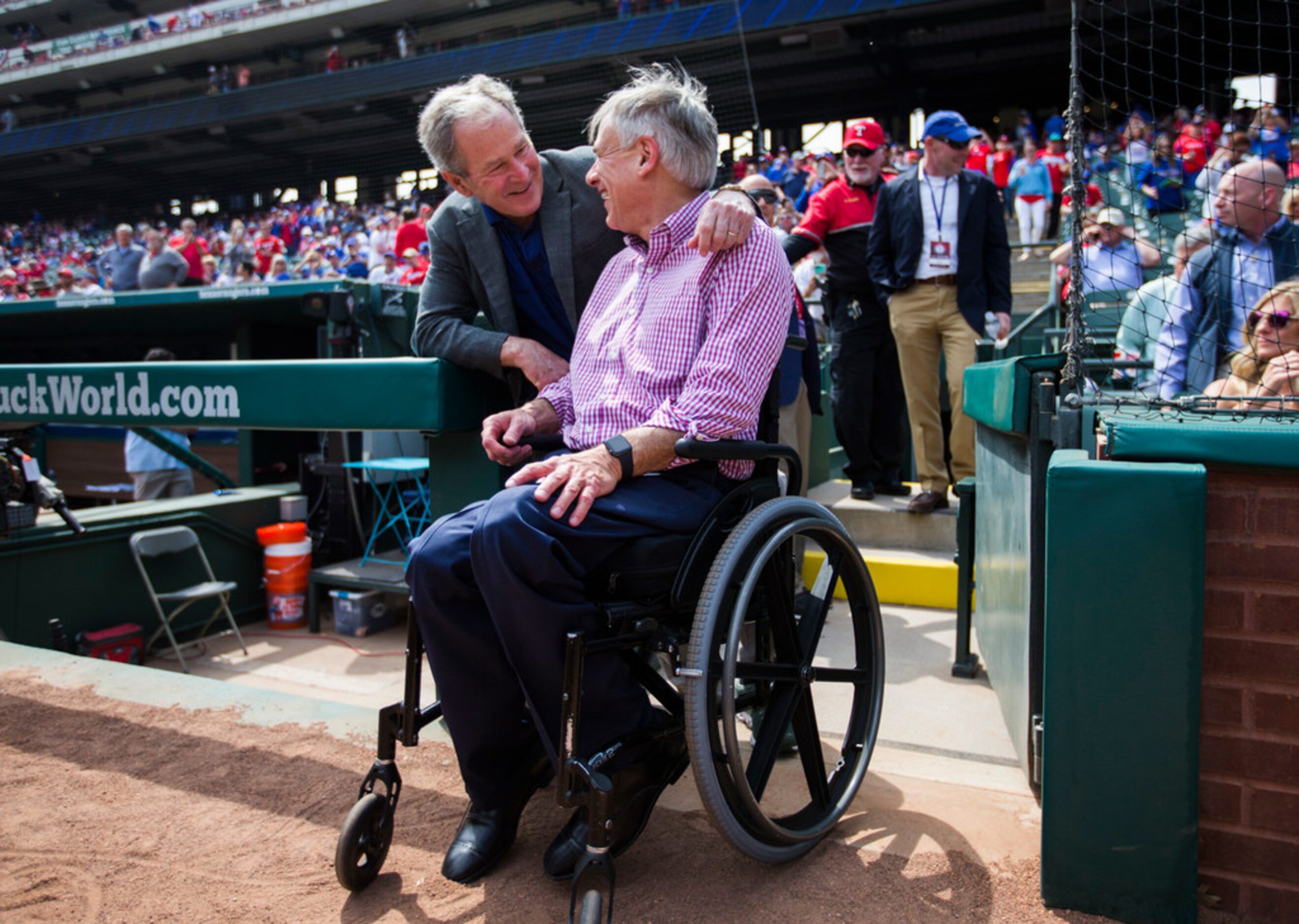 Former U.S. President George W. Bush greets Texas Governor Greg Abbott before an opening day...