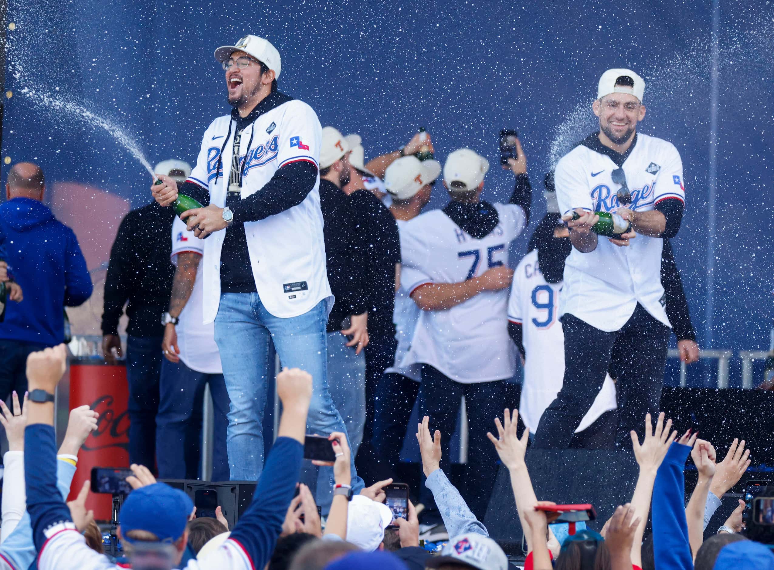 Texas Rangers Dane Dunning (left) and Nathan Eovaldi spray champagne during post-parade...