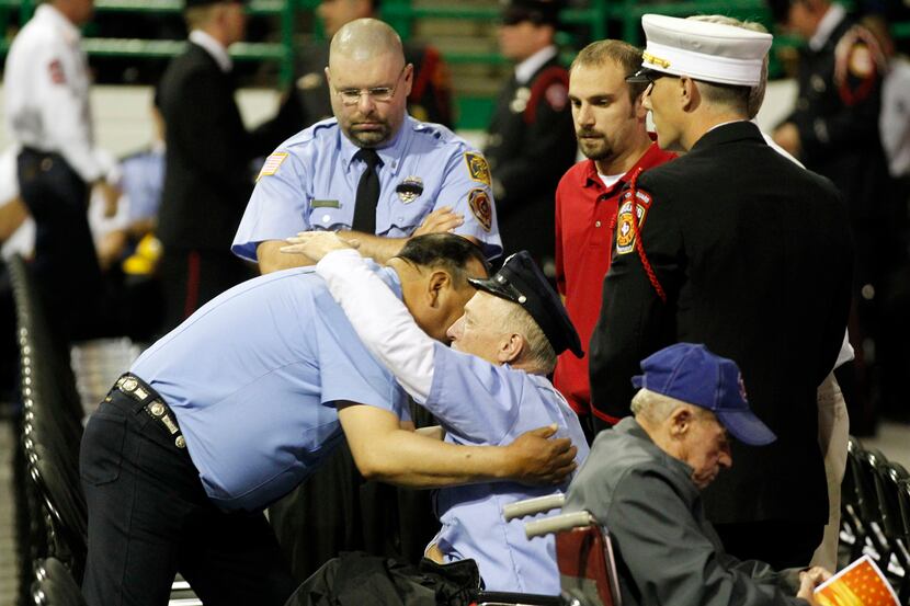 West firefighters console each other before a memorial service for first responders who died...
