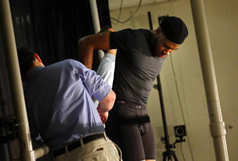 Student D'Marquis Allen is helped out of electrodes after taking part in a demonstration on...
