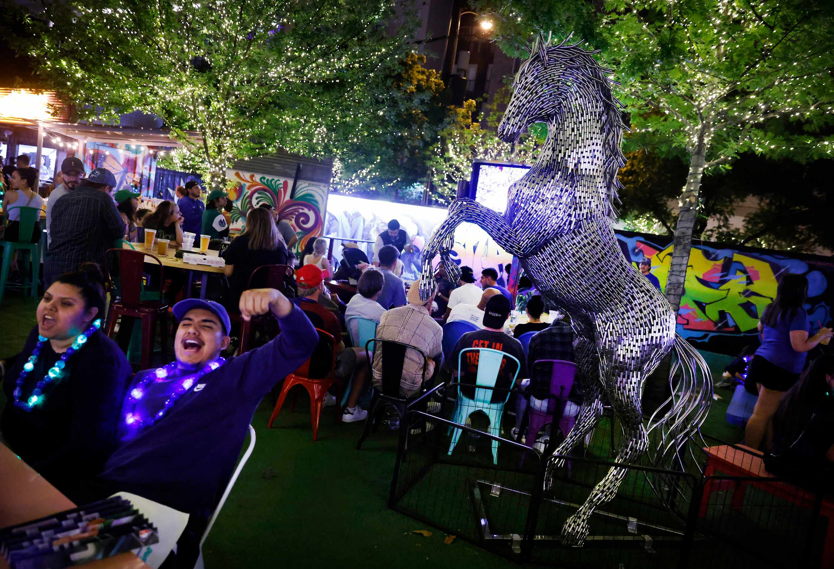 Dallas Mavericks fans cheer during a Game 6 watch party at ArtPark Trinity Groves in Dallas,...