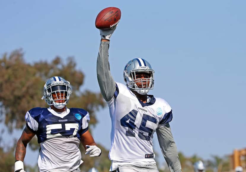 Dallas Cowboys running back Rod Smith (45) raises the ball after he scores a touchdown past...