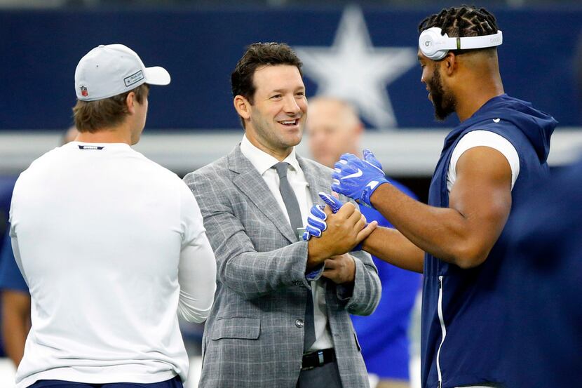 Former Dallas Cowboys quarterback and CBS sportscaster Tony Romo (center) is greeted by...