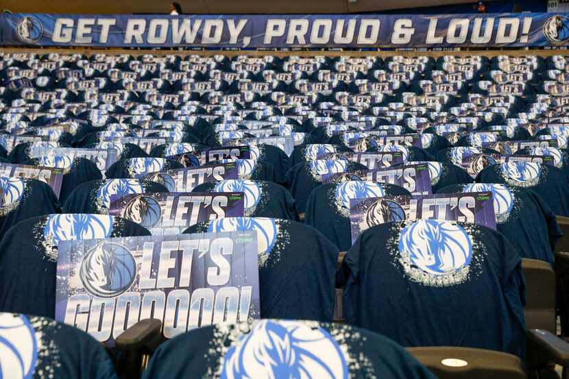 Dallas Mavericks shirts and signs fill the seats in the American Airlines center before the...