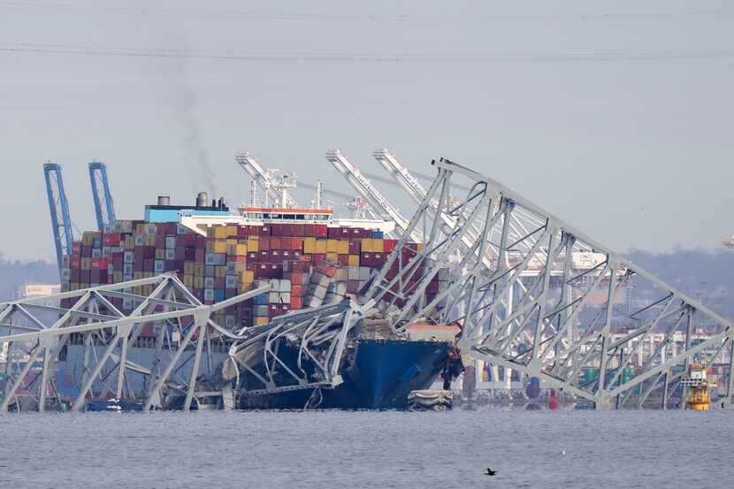 A container ship rests against wreckage of the Francis Scott Key Bridge on Tuesday, March...